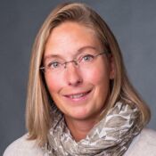 Eine Frau mit schulterlangen, blonden Haaren lächelt in die Kamera.